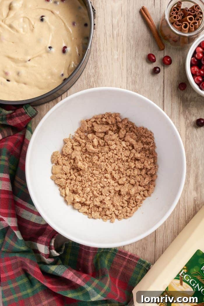 A bowl filled with the perfectly clumpy, golden-brown cinnamon streusel topping, ready to be scattered over the coffee cake batter.