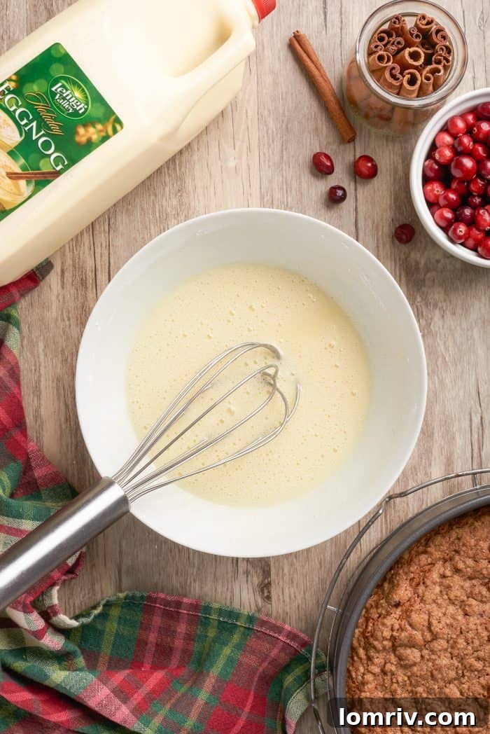 A white bowl with confectioner's sugar and eggnog being whisked together, demonstrating the preparation of the smooth, sweet eggnog glaze.