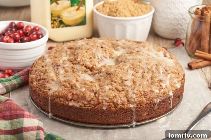 An enticing image of the entire cranberry eggnog coffee cake, beautifully iced, with drips cascading down its sides, emphasizing its festive appeal.