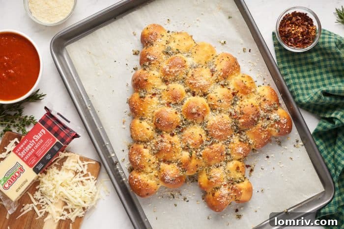The golden-brown Christmas tree pull-apart bread, garnished with fresh herbs, sits proudly on a baking sheet, ready for serving.
