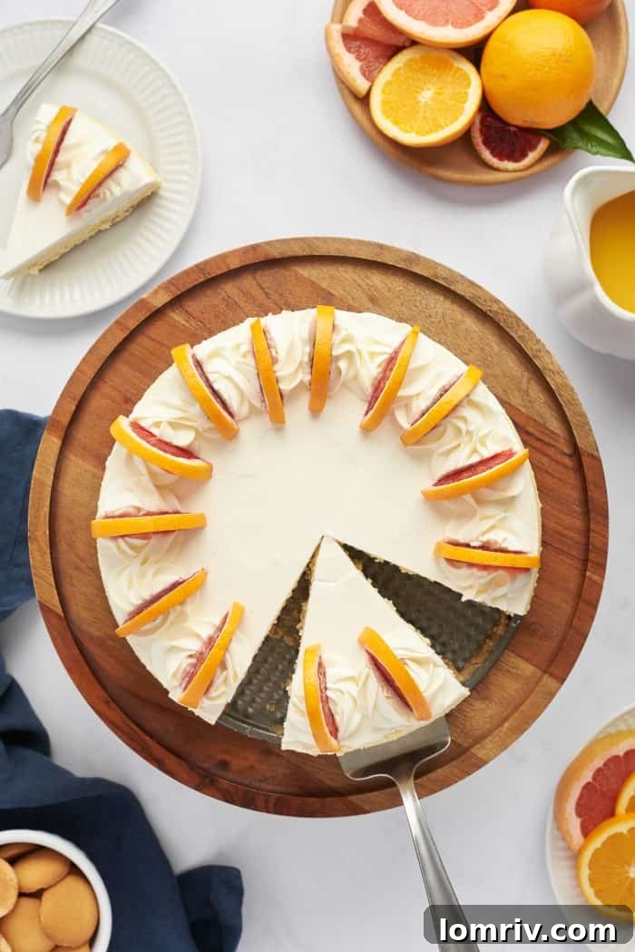 A close-up view of the top of the blood orange cheesecake, showing the beautifully arranged slices of blood orange and a piece removed.