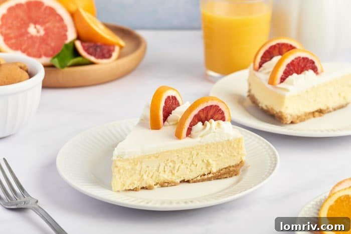 Two white plates, each holding a perfect slice of blood orange cheesecake, ready for serving.