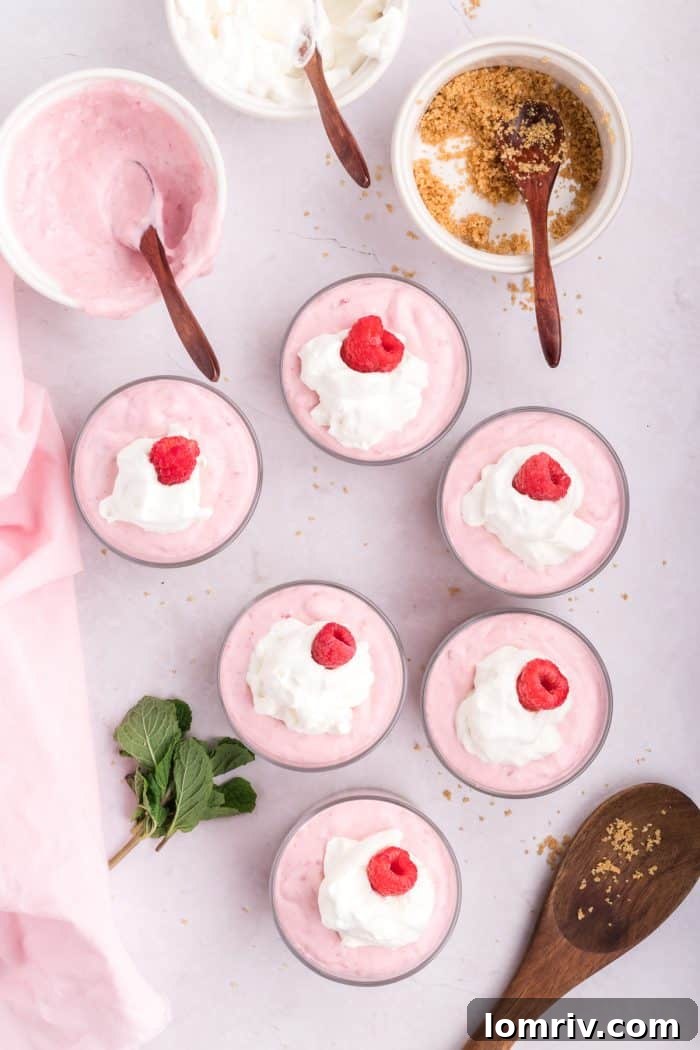 Each mousse is garnished with a fresh raspberry on top.
