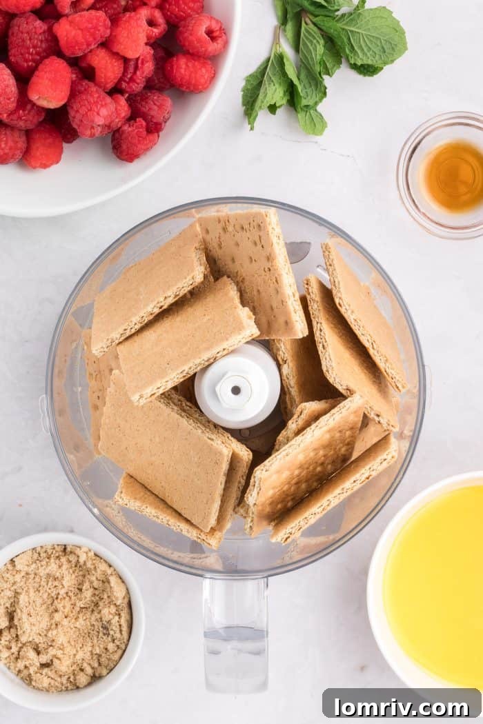 Graham crackers being added to a food processor.