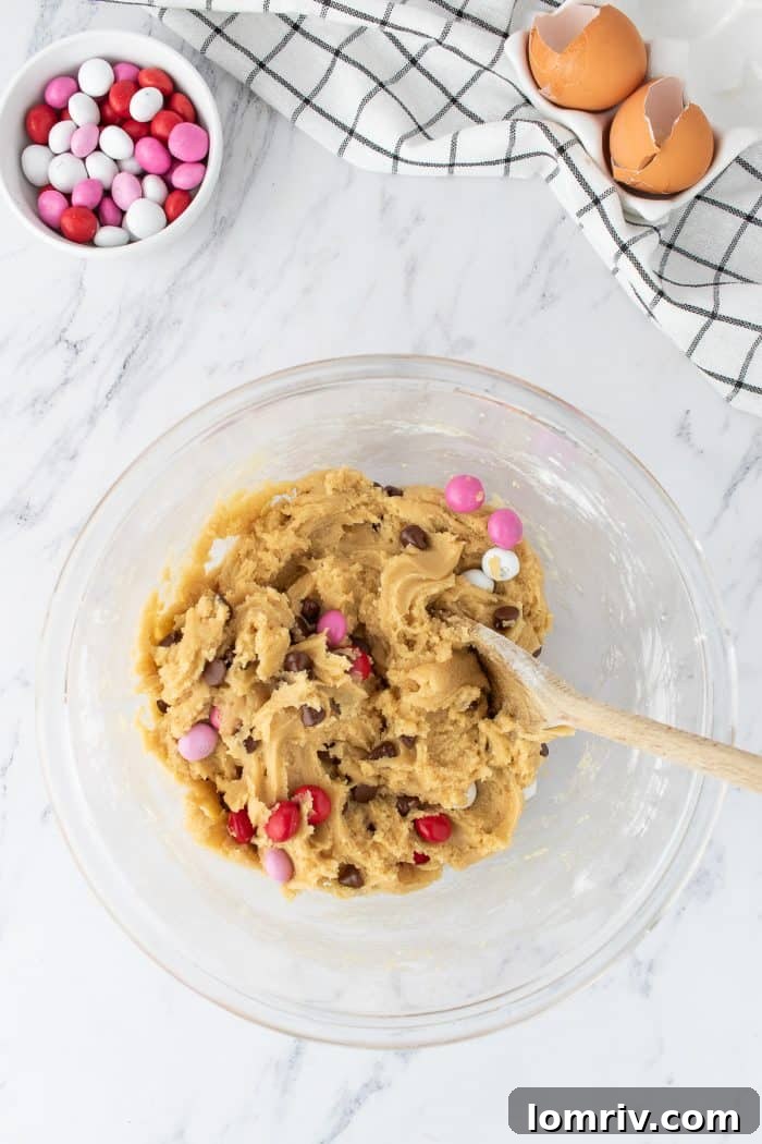Another perspective of the cookie dough, showcasing the generous amount and even distribution of Valentine's M&M's and chocolate chips.