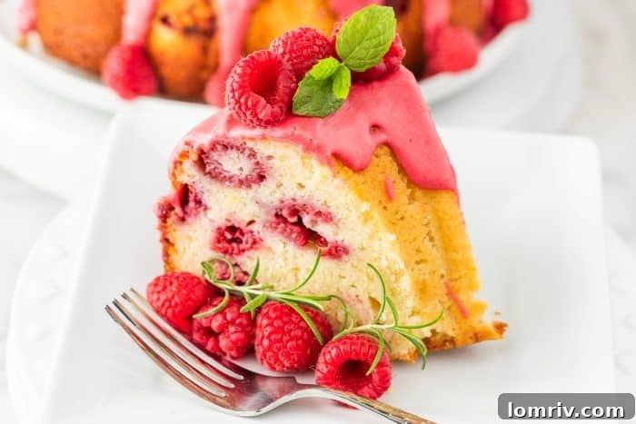 A final close-up of a slice of lemon raspberry bundt cake with a fork on a white plate, inviting a taste.