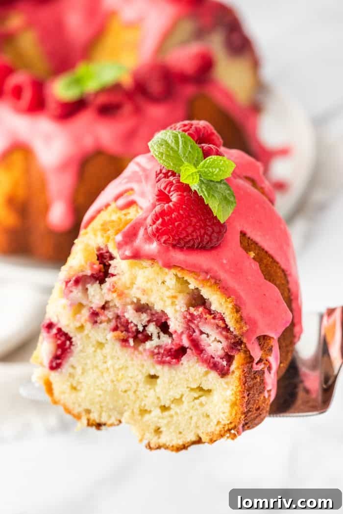 A perfectly baked slice of lemon raspberry bundt cake, showing the even distribution of raspberries.