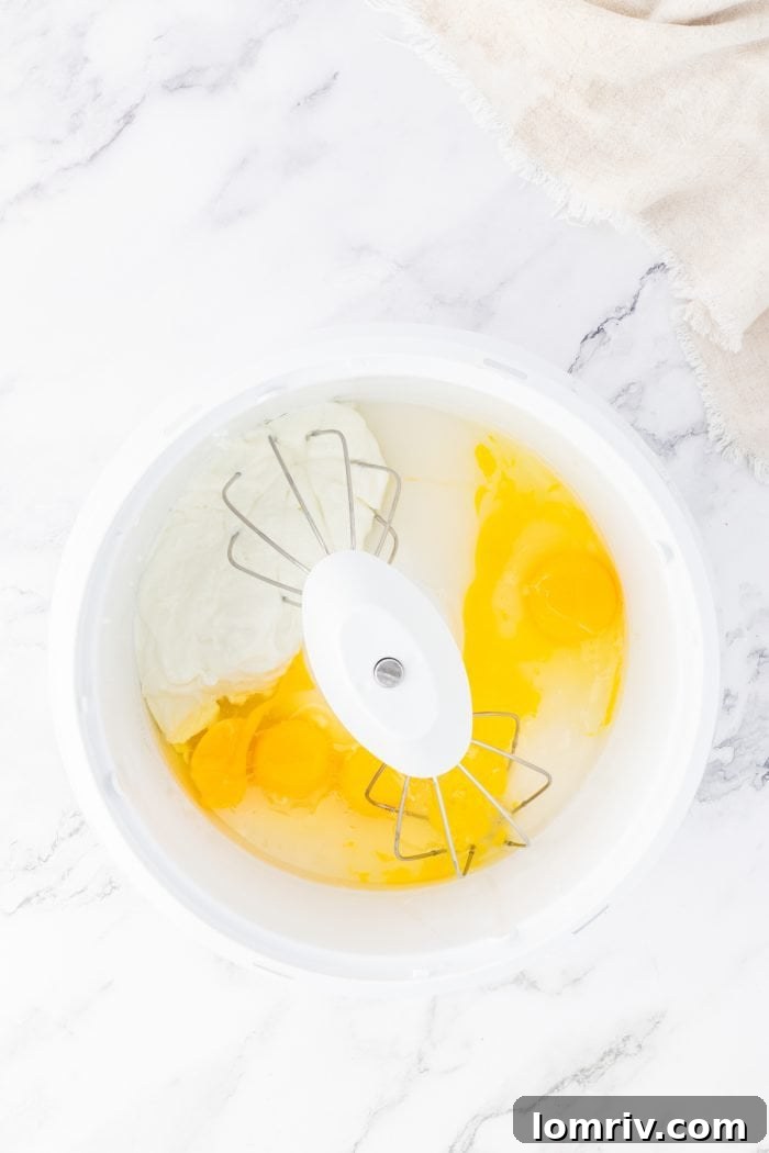 Wet ingredients being combined in a white bowl with a whisk, creating a smooth mixture.
