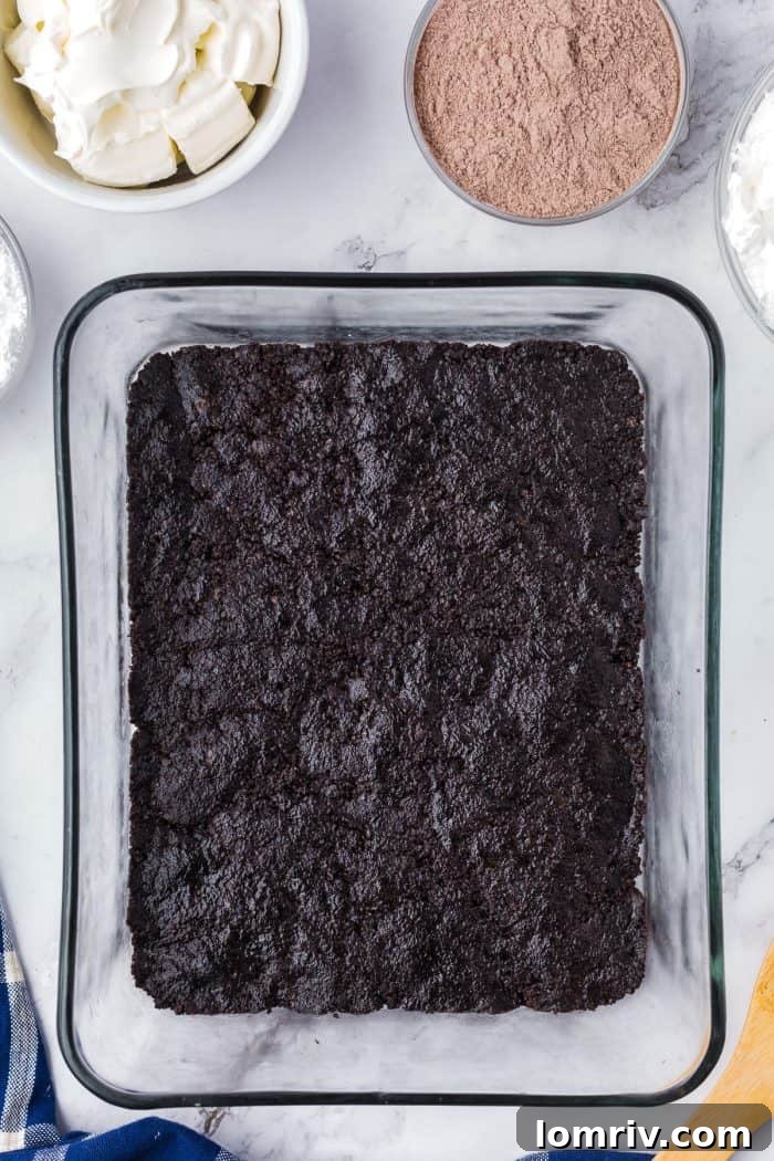 Oreo cookie crumbs pressed into a glass dish.
