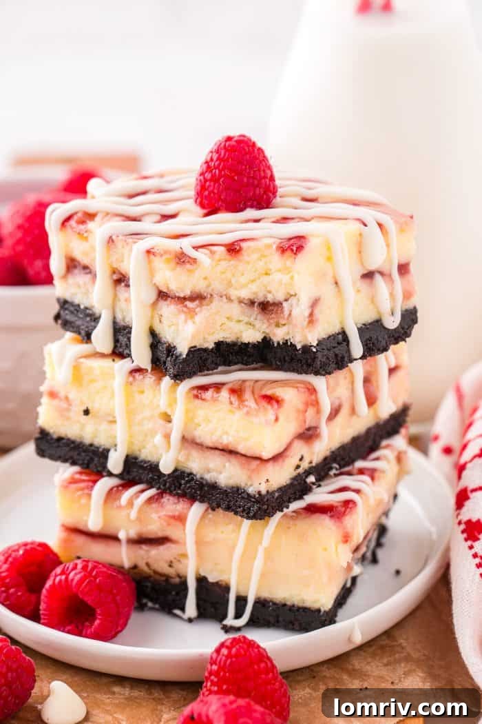 A stack of three white chocolate raspberry cheesecake bars on a white plate, one with a delectable bite taken out of it, revealing the layers.