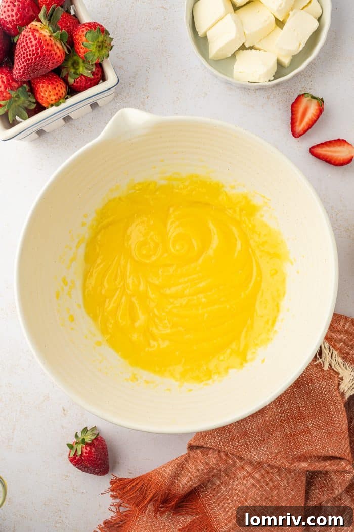 A bowl of creamy vanilla pudding mixture with a hint of lemon, ready to be folded with whipped cream.