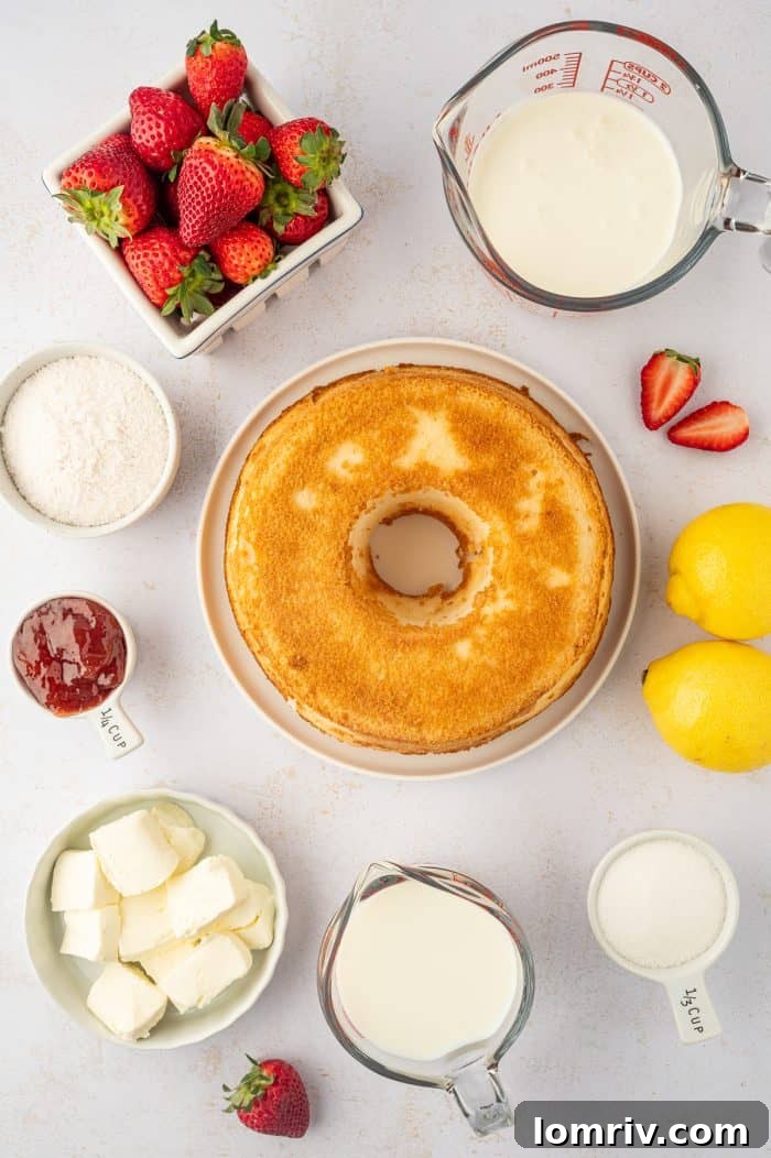 An overhead view of all the essential ingredients laid out on a white surface, ready to be combined into a strawberry trifle.