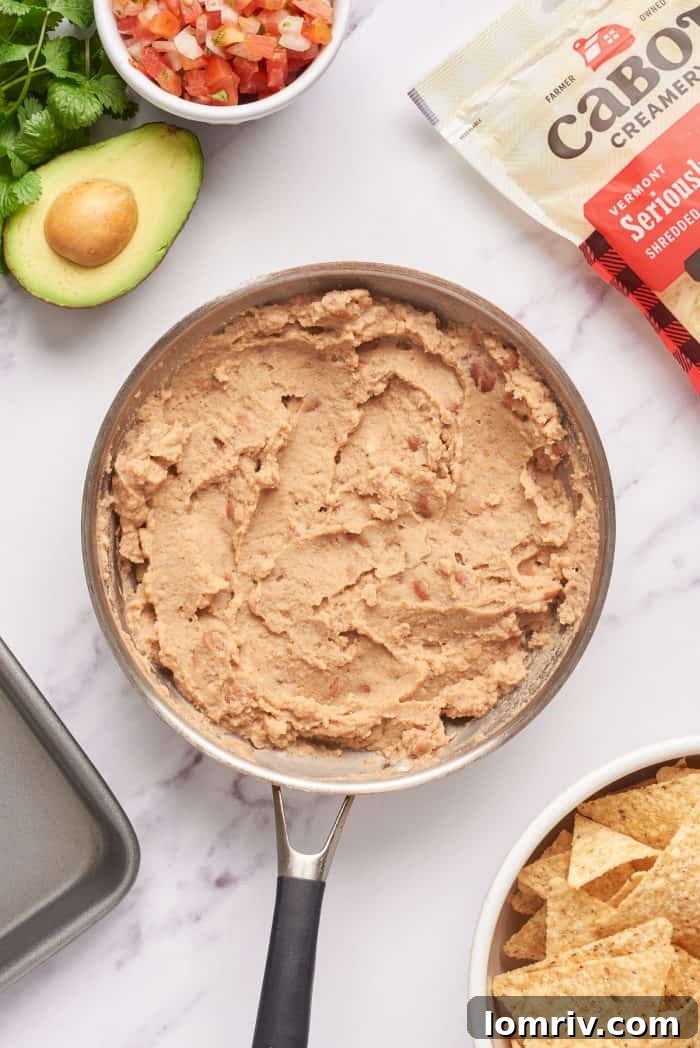 Heating the refried beans in a saucepan.