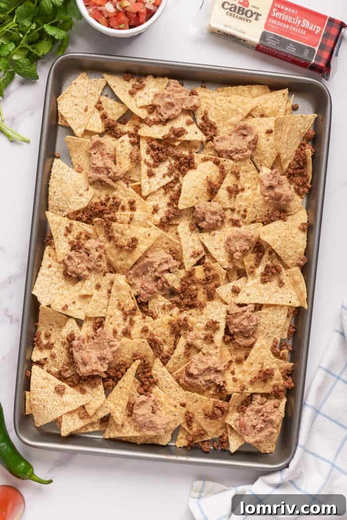 Tortilla chips with a layer of ground beef and refried beans.