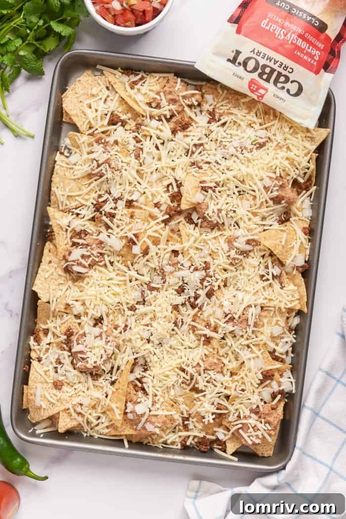 Tortilla chips with a layer of ground beef, refried beans, and cheese.