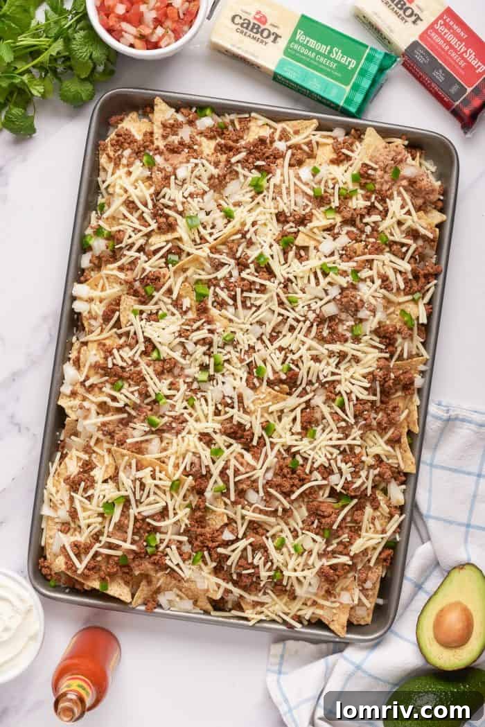 Tortilla chips with a layer of ground beef, refried beans, and cheese.
