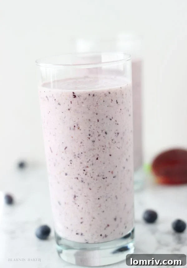 A tall glass of refreshing Peach Blueberry Oatmeal Smoothie, ready to be enjoyed
