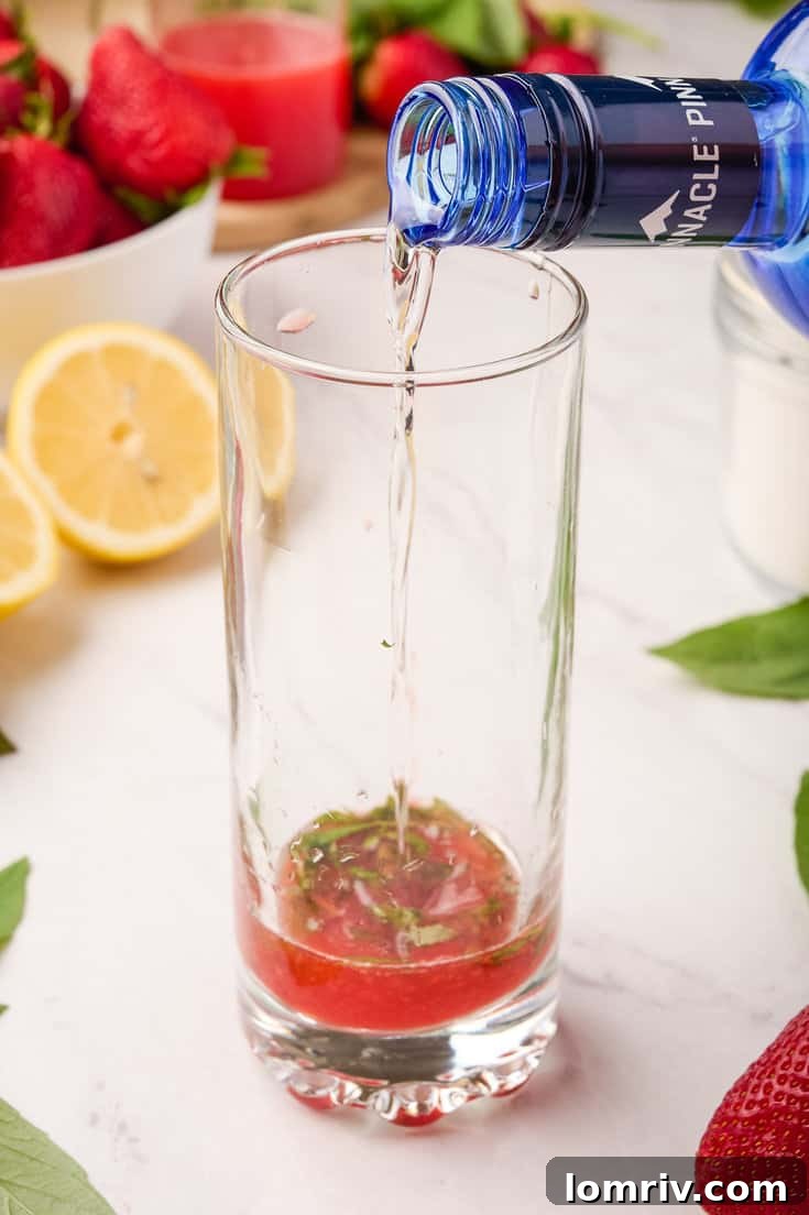 Topping the Strawberry Basil Sparkler with sparkling water