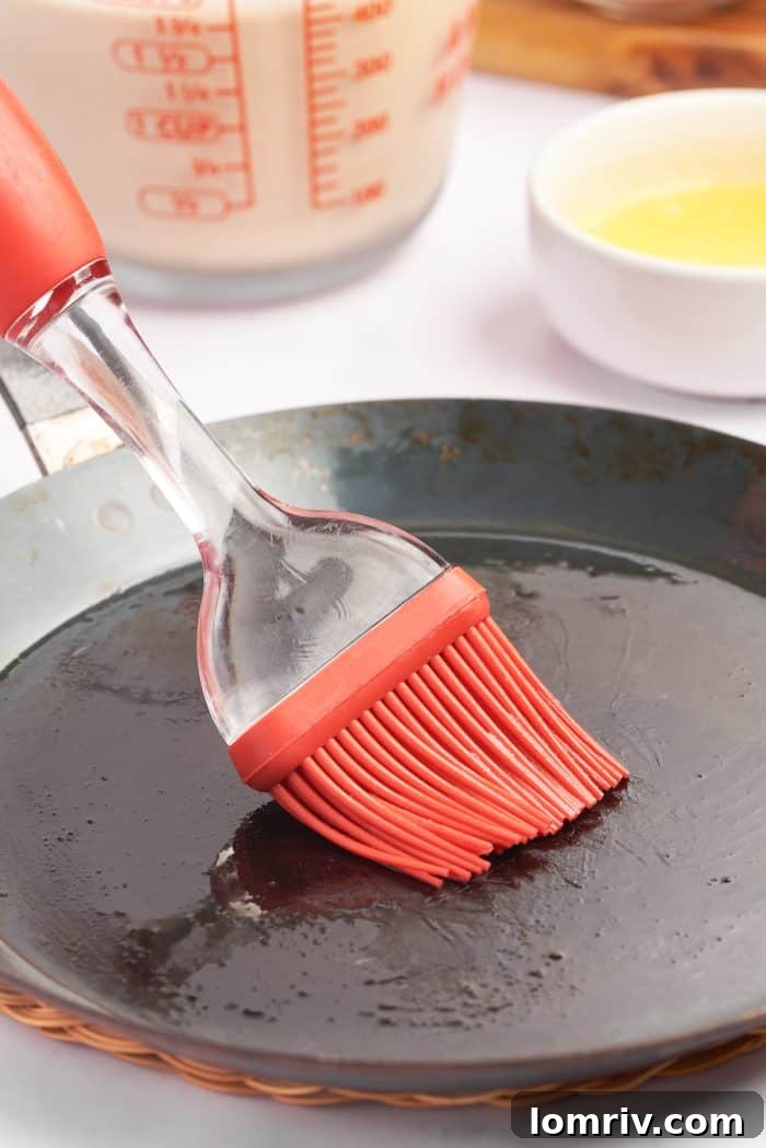 Brushing a crepe pan with butter. 
