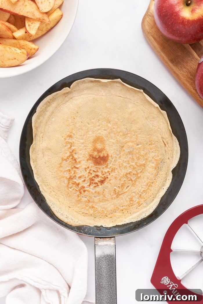 A crepe pan with a cooked crepe on it.
