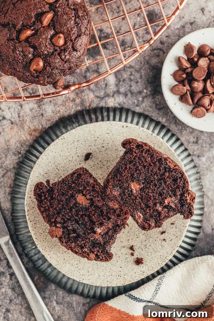 A plate with a double chocolate muffin that has been sliced in half to show how chocolatey it is.