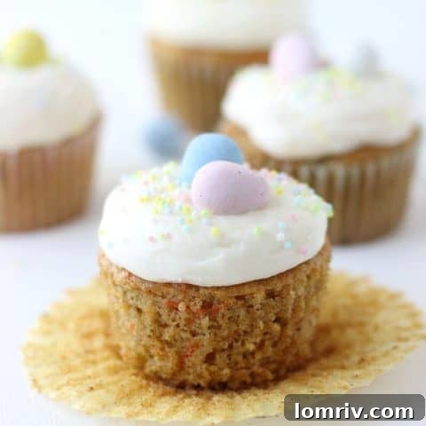 Perfectly piped carrot cake cupcakes with a luscious mascarpone cream cheese frosting, sprinkled with cinnamon.