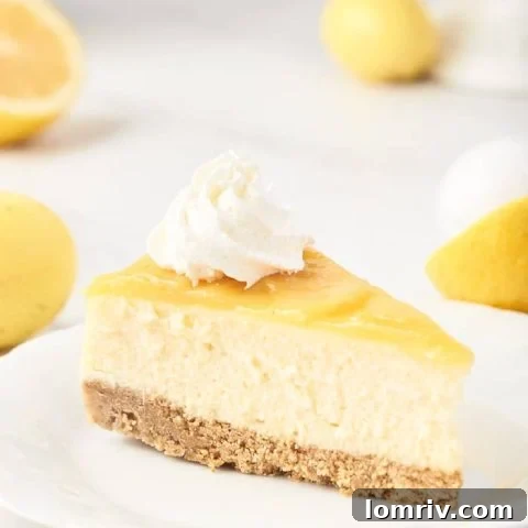 A rich, creamy lemon cheesecake adorned with a generous layer of homemade lemon curd and fresh whipped cream.