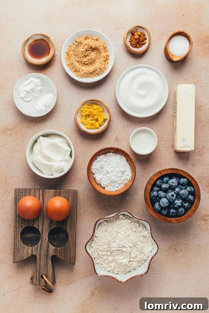 An array of fresh ingredients for blueberry sour cream coffee cake, neatly arranged in small bowls, ready for baking.
