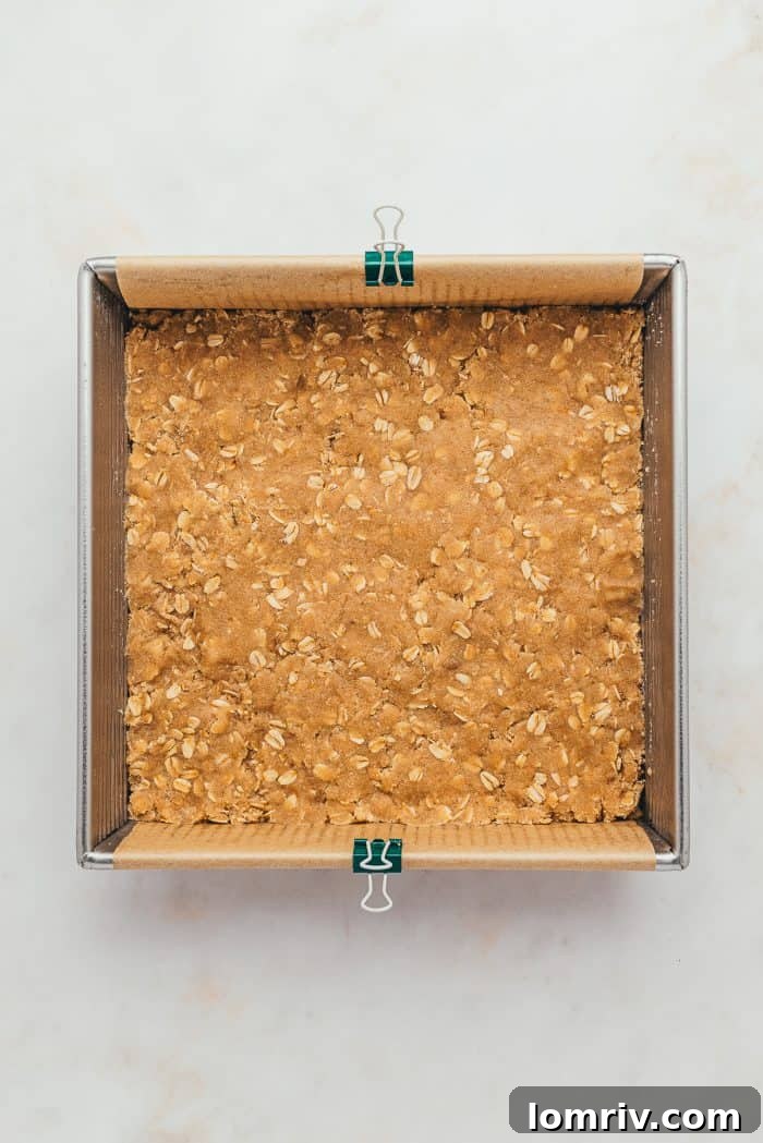 A baking tray lined with parchment paper and the unbaked crust.