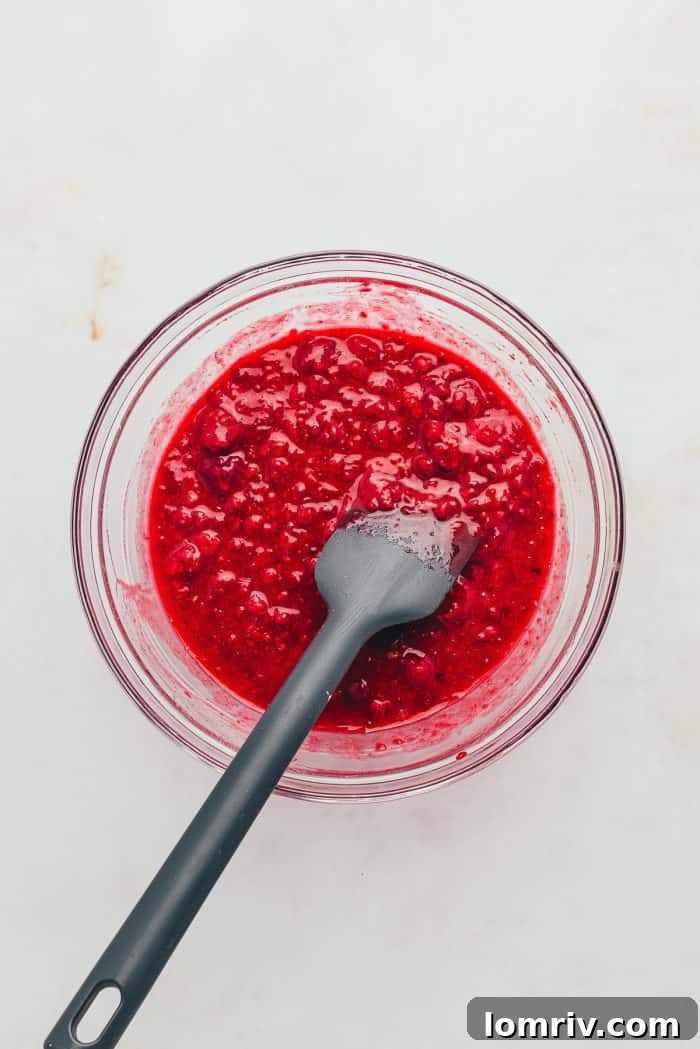 A glass bowl filled with raspberry filling.