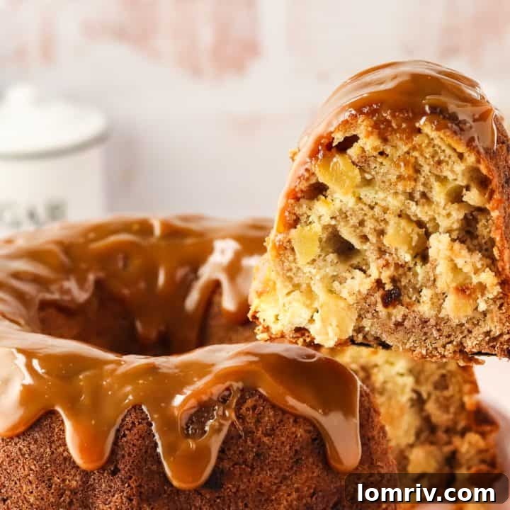 An image of a slice of caramel apple Bundt cake on a cake lifter being removed from the whole cake.