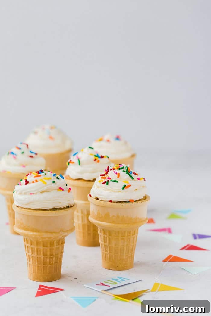 A plate full of beautifully decorated Funfetti Ice Cream Cone Cupcakes