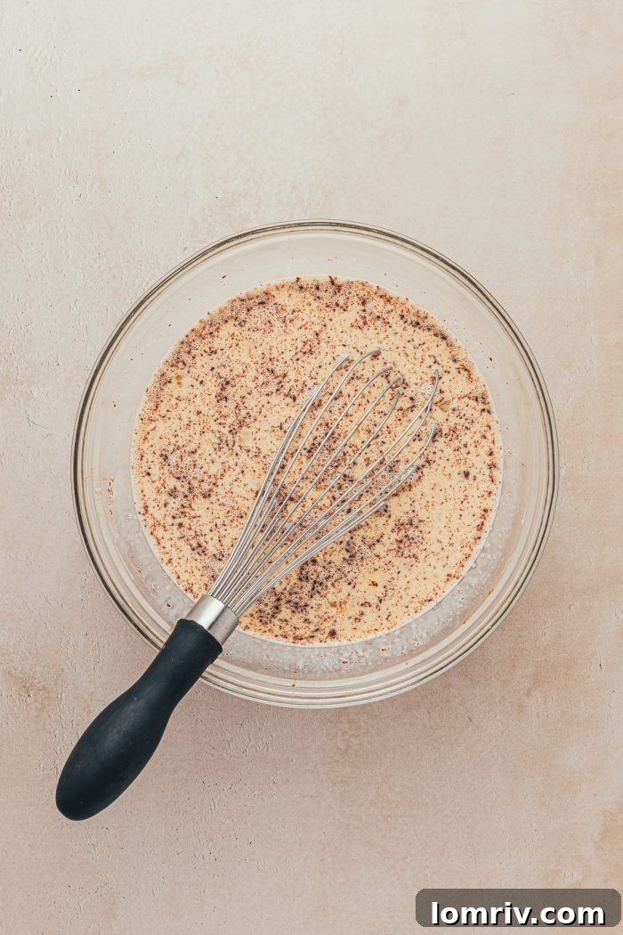 Milk mixed with eggs and spices with a whisk.