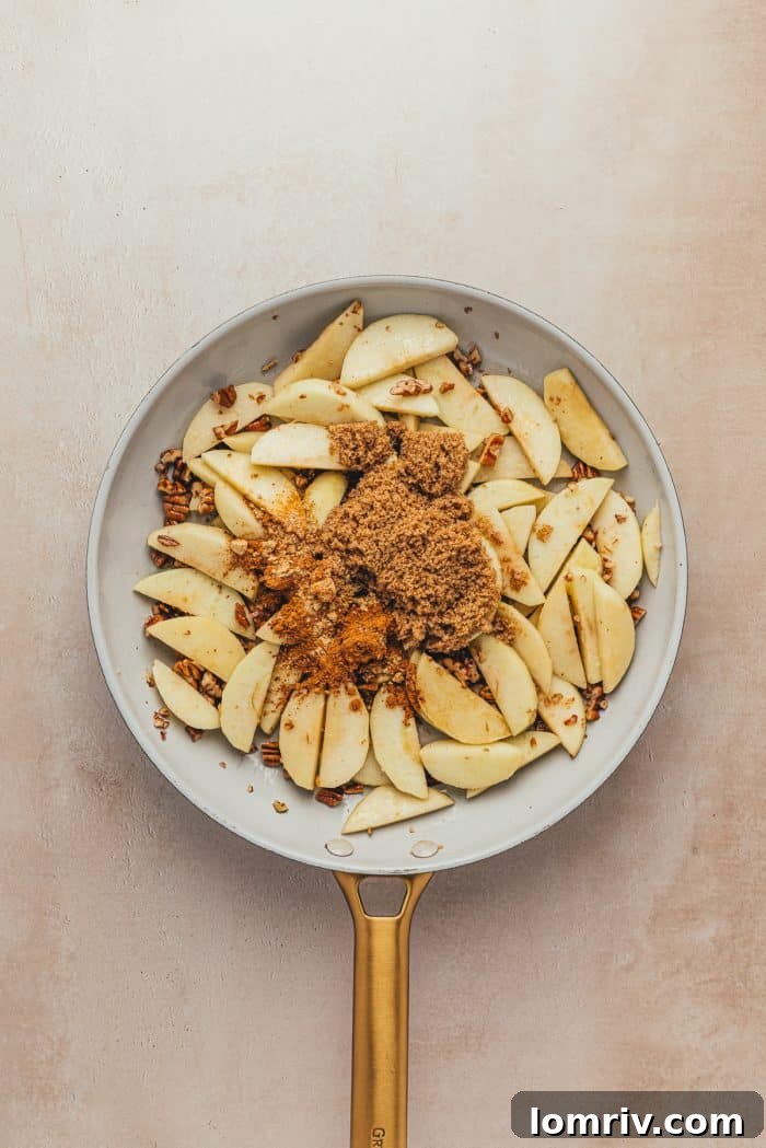 Sliced green apples in a skillet with brown sugar.