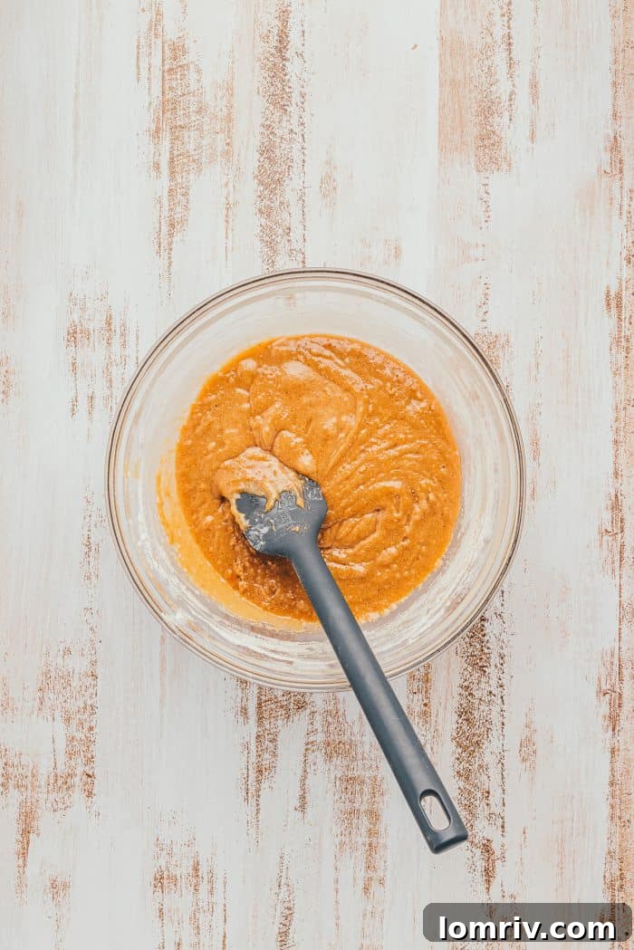 The batter for Apple Blondies in a glass bowl with a spatula.