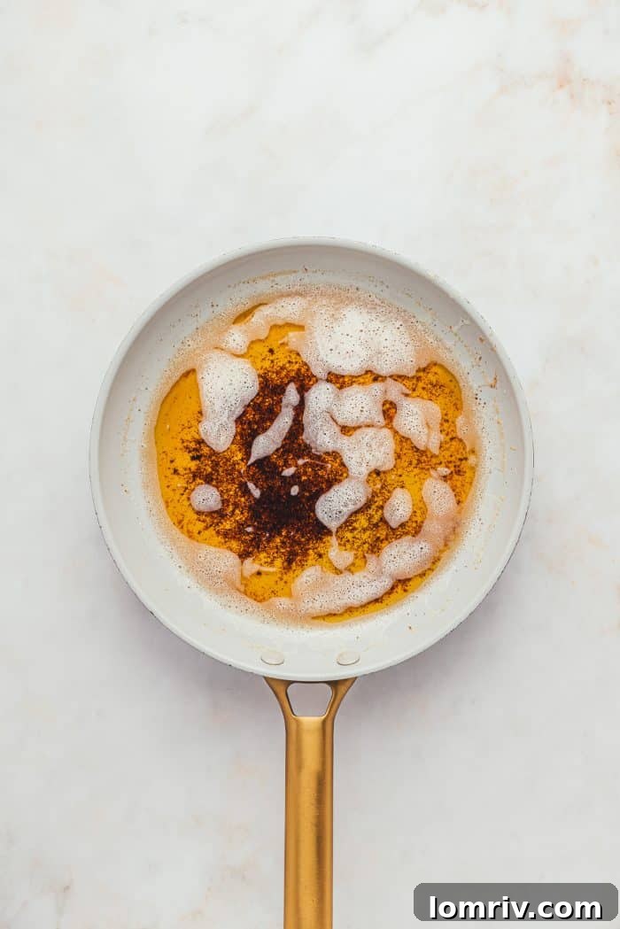 A pan with perfectly melted browned butter, showing its rich, golden-brown hue and nutty milk solids.