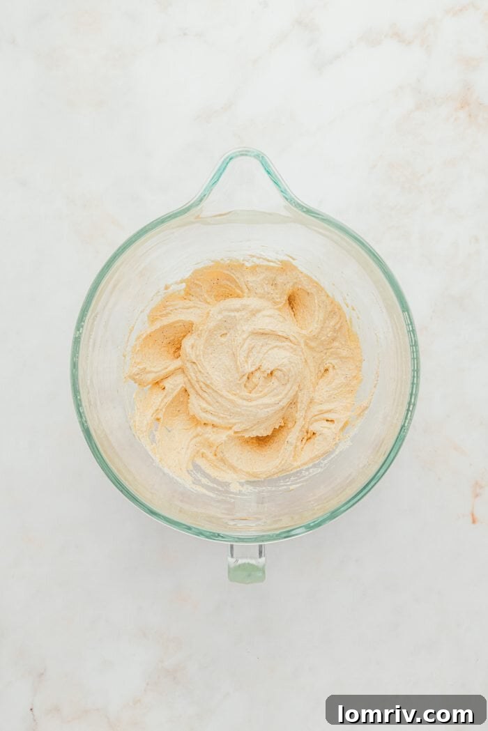 A glass bowl containing creamed browned butter, granulated sugar, and brown sugar, perfectly mixed.