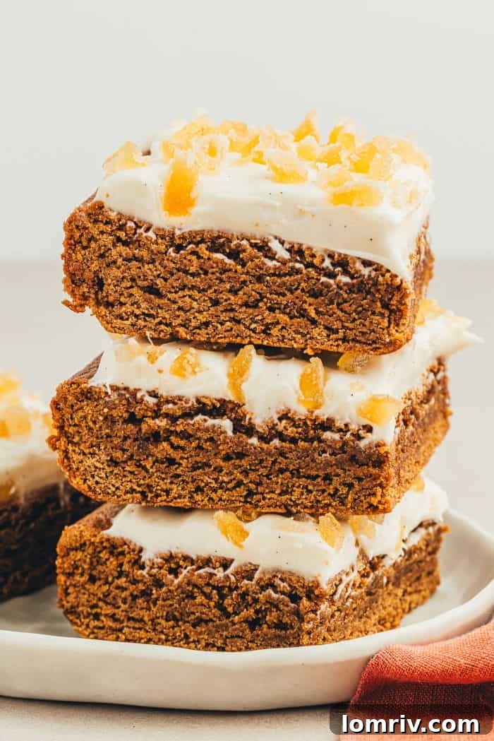 Another elegant stack of frosted gingerbread bars on a gray plate, emphasizing their uniformity and delicious frosting.
