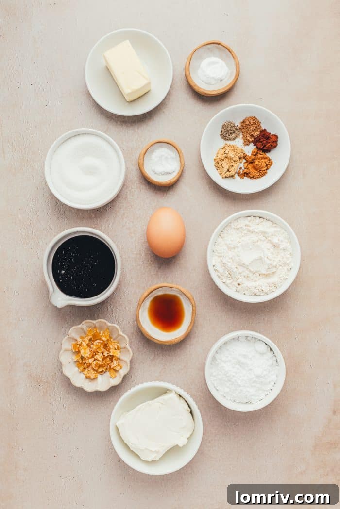 Various ingredients for frosted gingerbread bars, including flour, spices, butter, molasses, and cream cheese, neatly arranged in bowls.