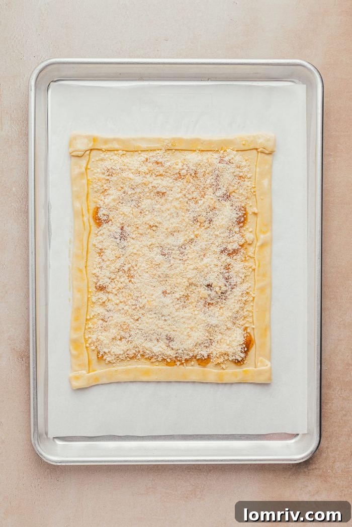 Parmesan cheese delicately sprinkled over a layer of fig preserves on puff pastry.