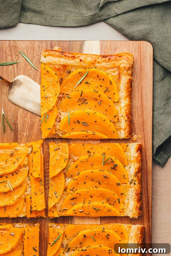 Perfectly thin slices of raw butternut squash arranged on a rustic wooden cutting board, ready for preparation.
