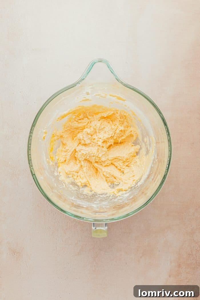 A glass measuring cup filled with softened unsalted butter, ready to be creamed for the cookie dough.