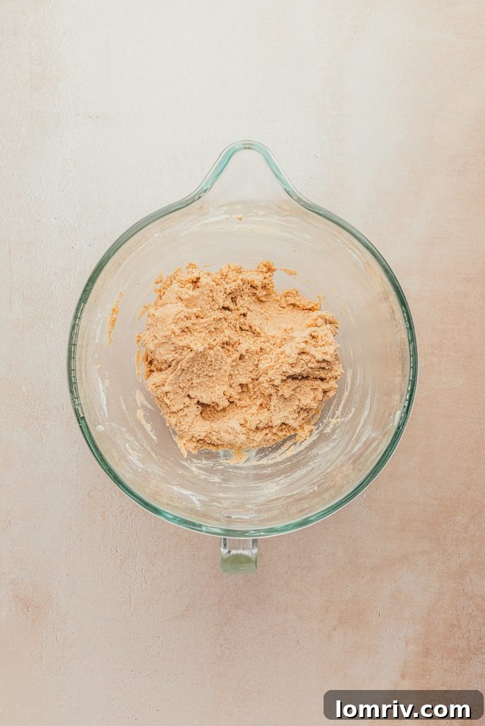 A glass measuring cup containing freshly mixed cookie batter, smooth and ready for the next step.