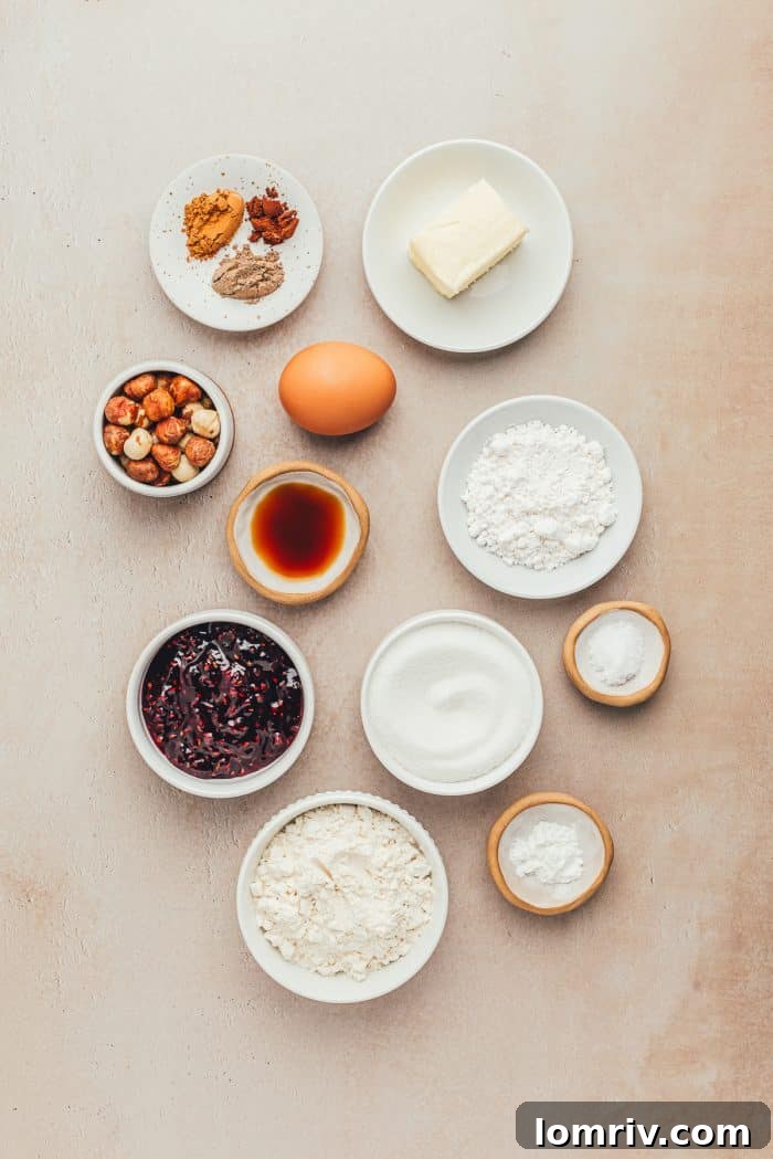 Various bowls holding the essential ingredients for Spiced Hazelnut Linzer Cookies, neatly arranged and ready for baking.