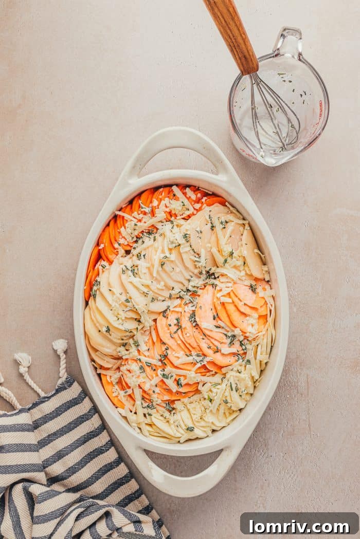Cream mixture being poured over the sliced root vegetables in a baking dish.