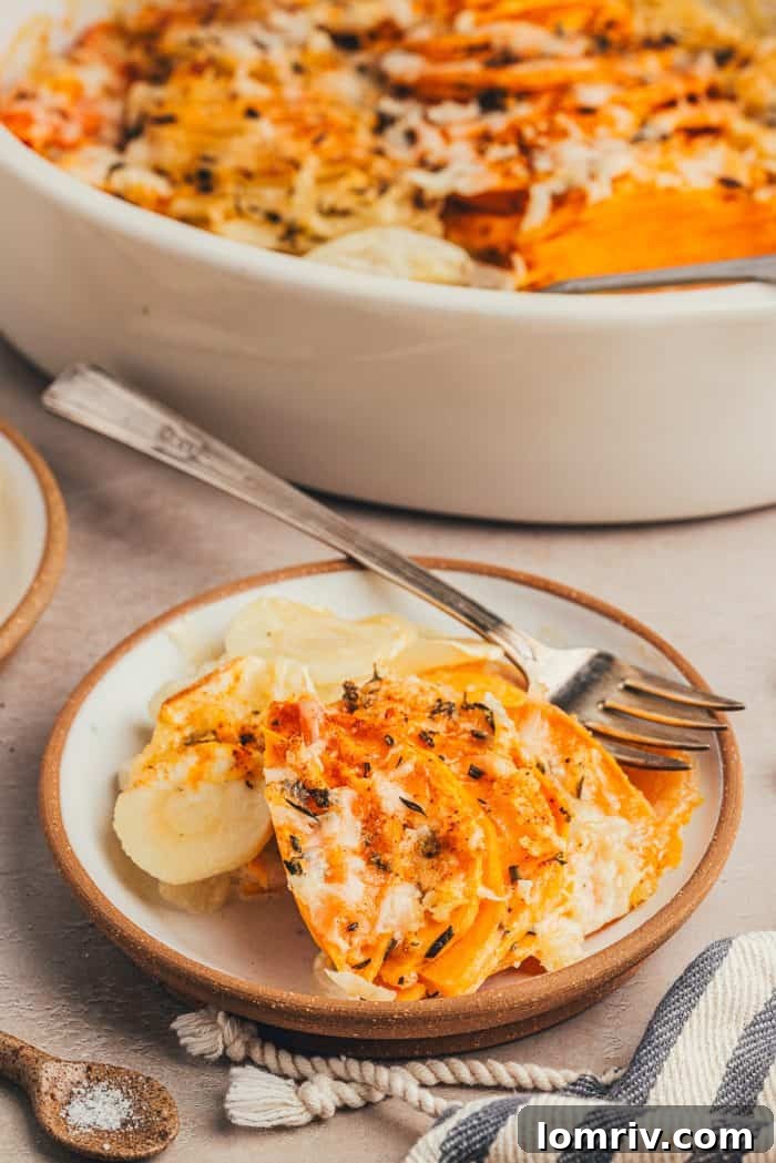 A close-up of a serving of root vegetable gratin, showing the layers and melted cheese.