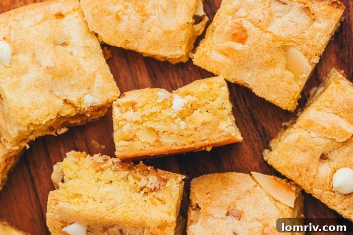 A beautiful array of lemon blondies scattered appealingly across a warm wooden background, highlighting their golden hue and delicious texture.