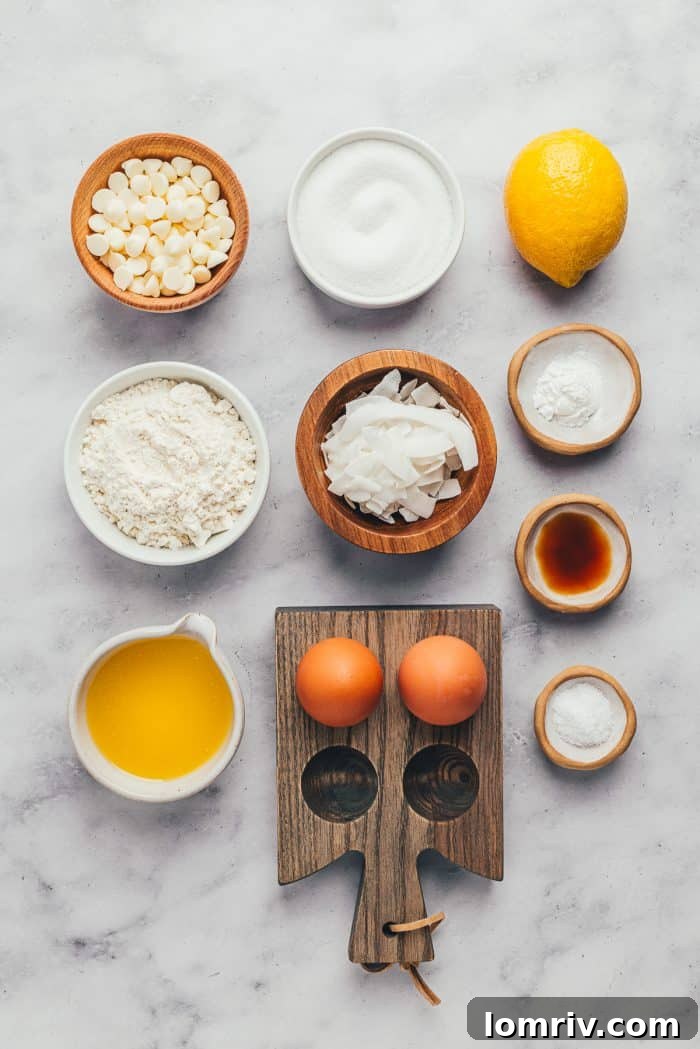 A flat lay of all the essential ingredients for making lemon blondies, including lemons, butter, sugar, flour, eggs, and chocolate chips.
