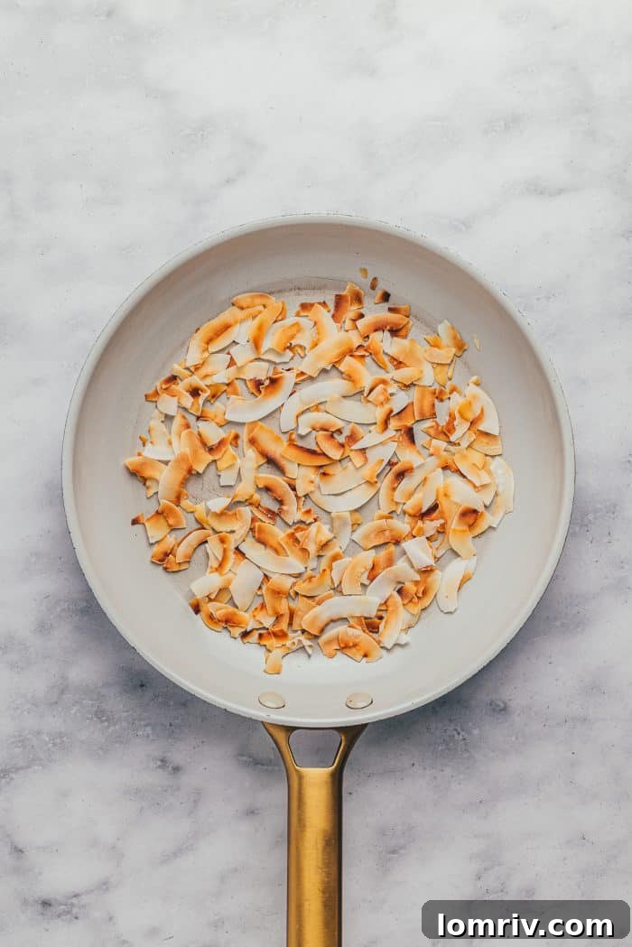 A skillet filled with golden-brown toasted coconut flakes.