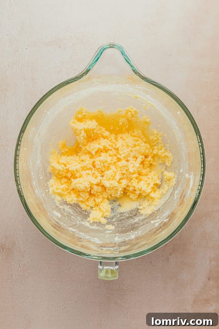 A glass bowl containing light yellow lemon sugar cookie batter, creamy and smooth.